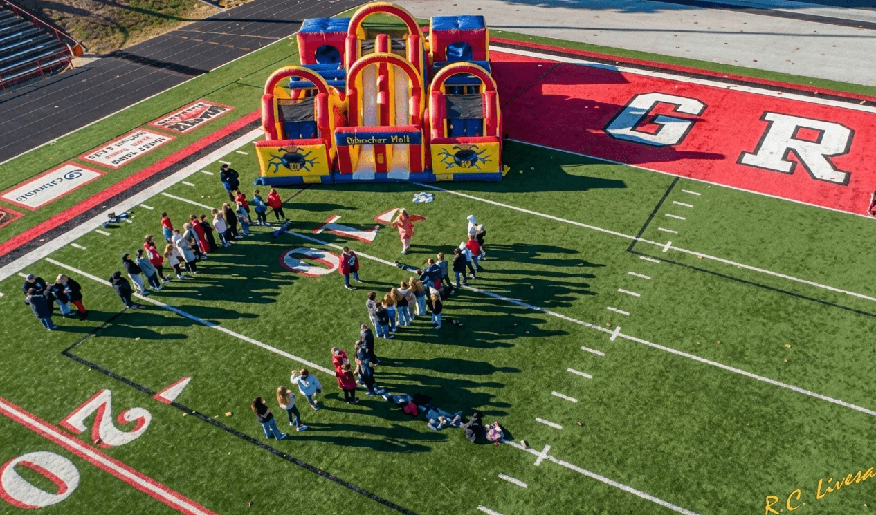 A community event with an inflatable and a group gathered outside.