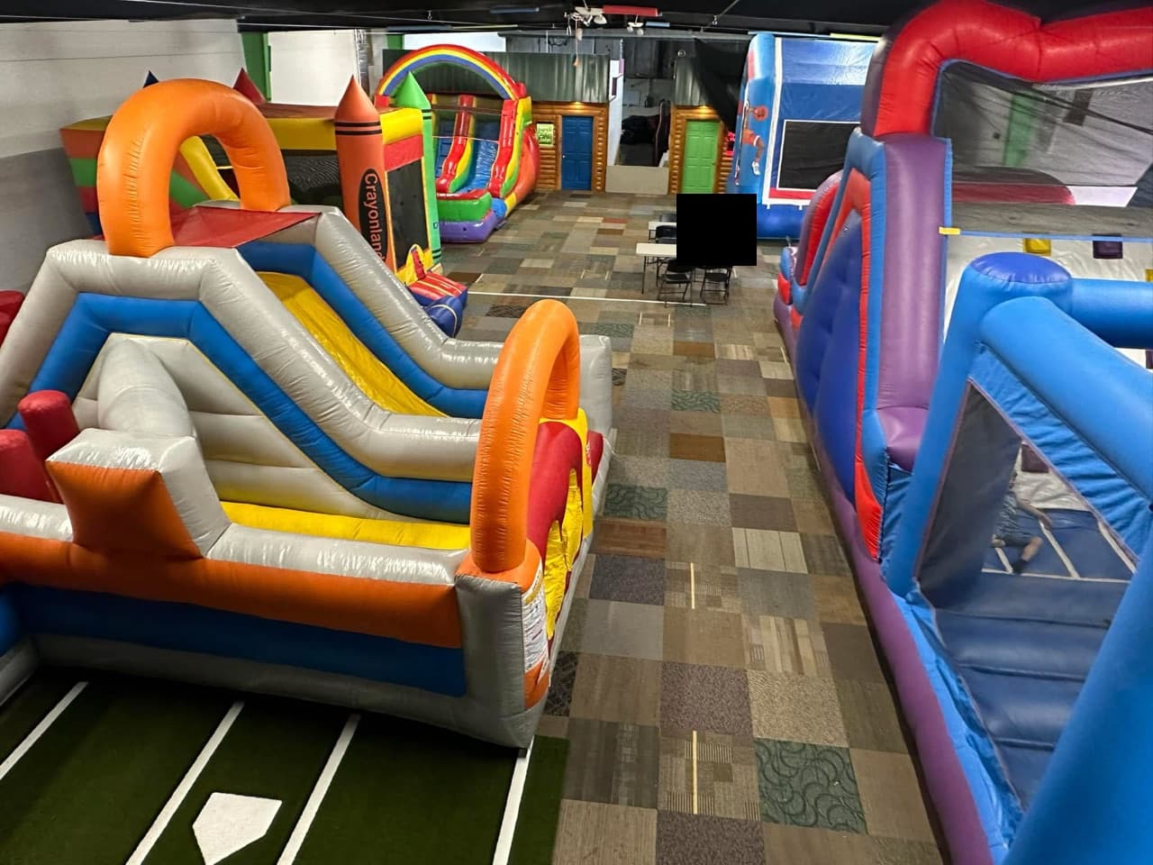 Inside the Grand Bounce facility with multiple inflatables set up.